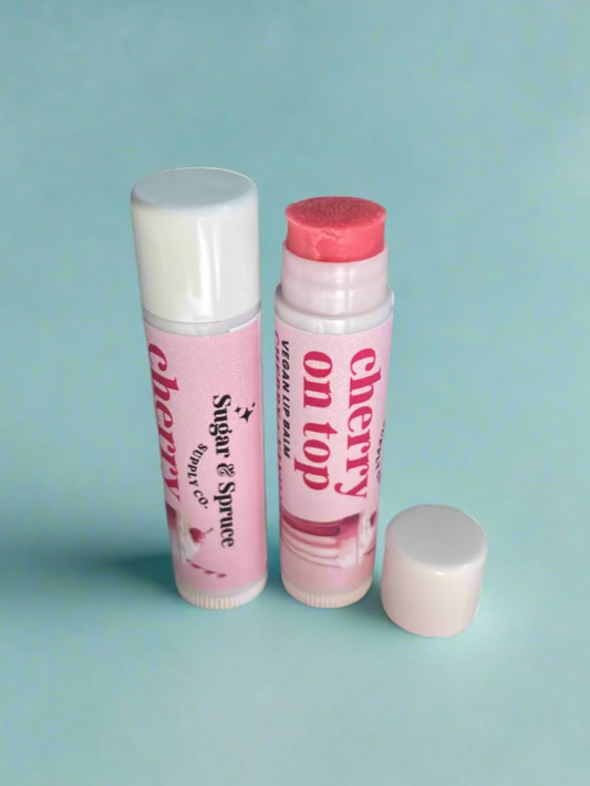 Two lip balms with visible branding on a countertop.