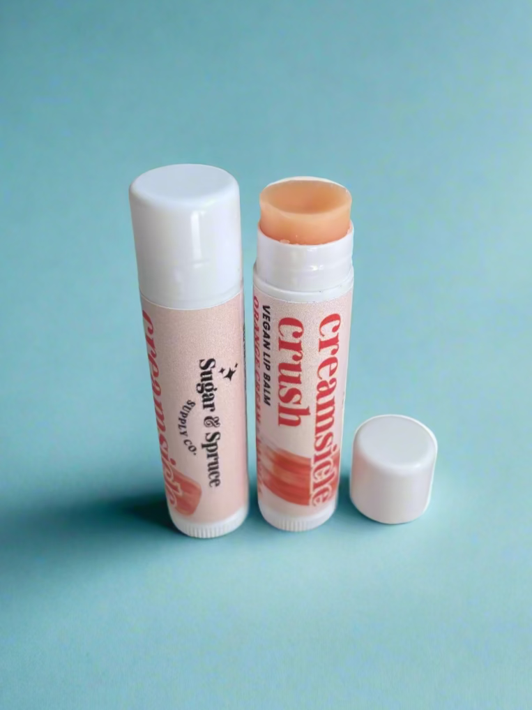 Two lip balms on a countertop with visible branding.