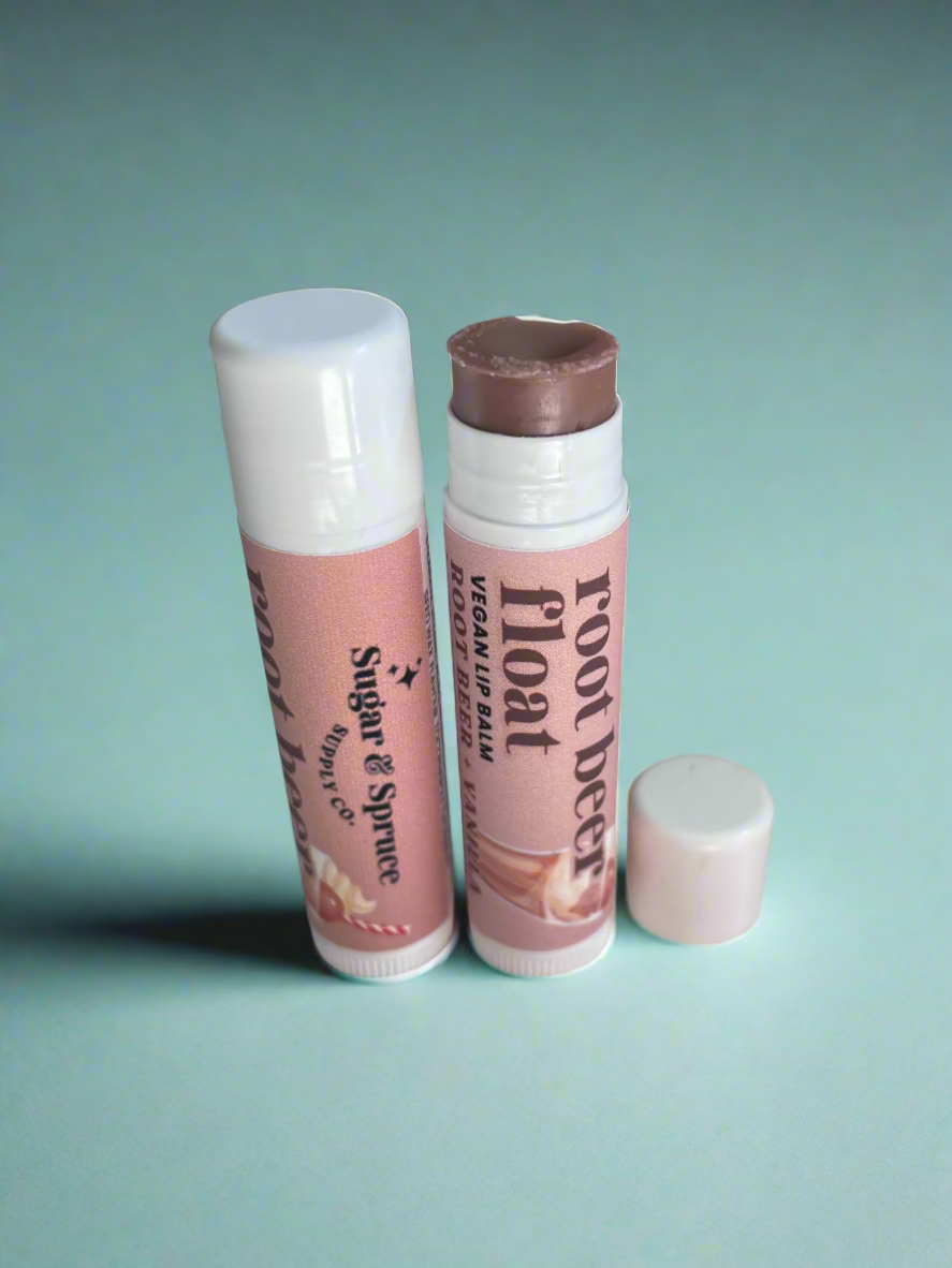 Two lip balm tubes on a countertop with blurred background